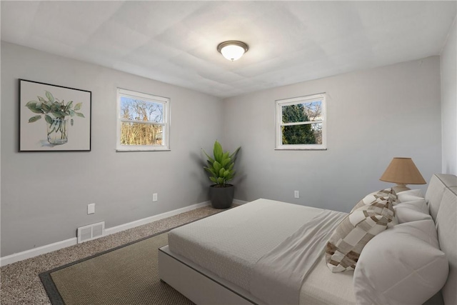 carpeted bedroom featuring visible vents and baseboards