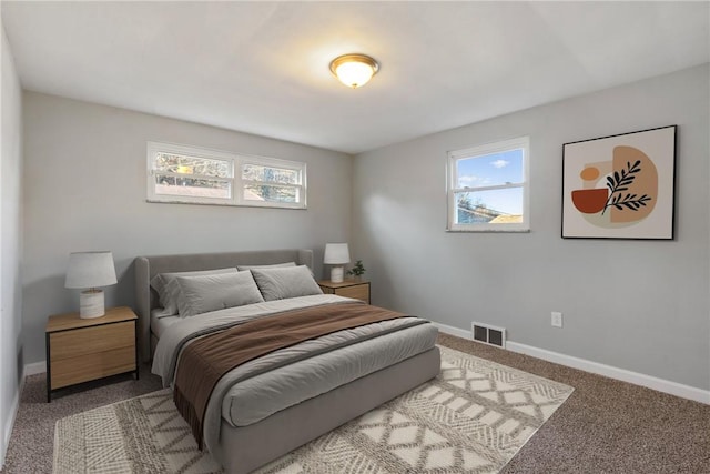 bedroom with multiple windows, baseboards, visible vents, and carpet floors