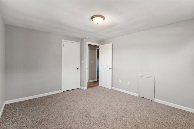 carpeted empty room featuring baseboards