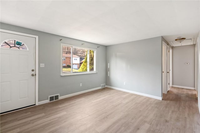 foyer entrance featuring visible vents, baseboards, and wood finished floors