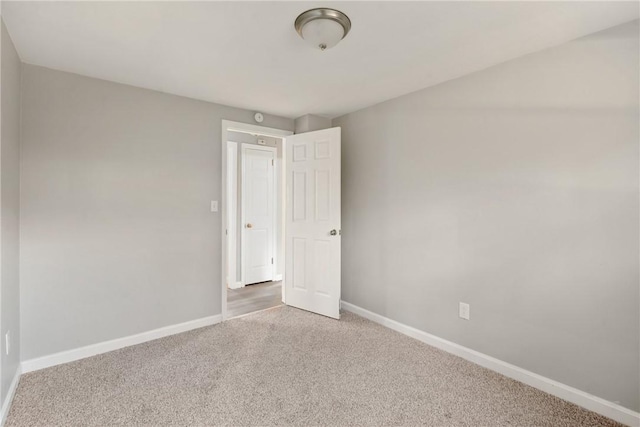 carpeted spare room with baseboards