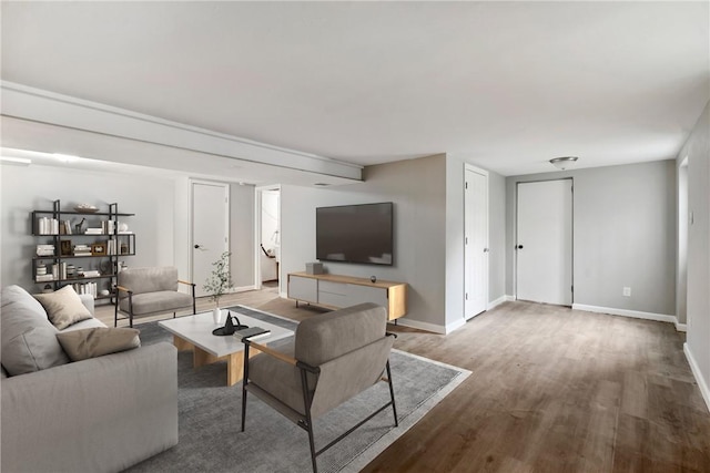 living area featuring baseboards and wood finished floors