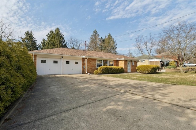 ranch-style home featuring concrete driveway, brick siding, a garage, and a front yard