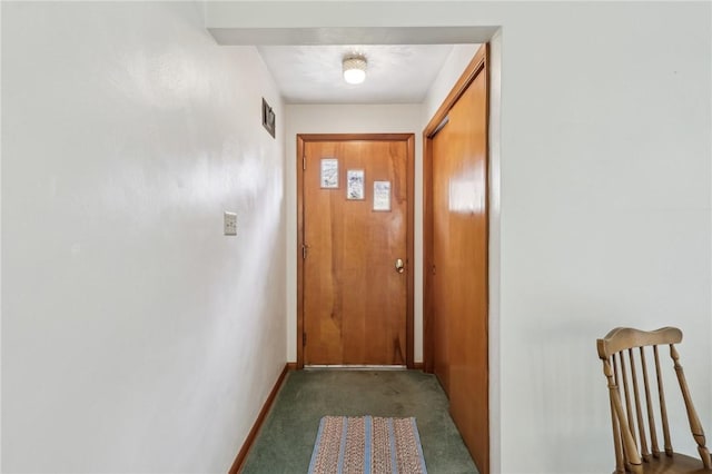 entryway with dark colored carpet, visible vents, and baseboards