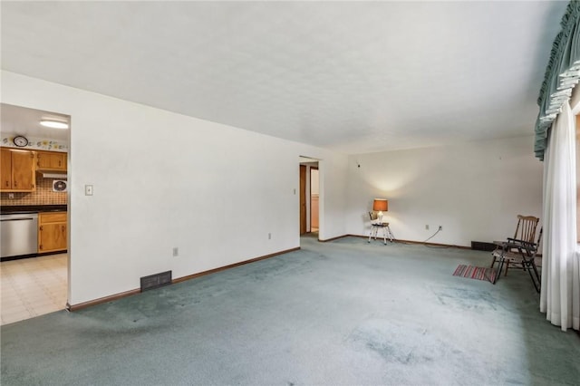 unfurnished living room with light colored carpet, baseboards, and visible vents