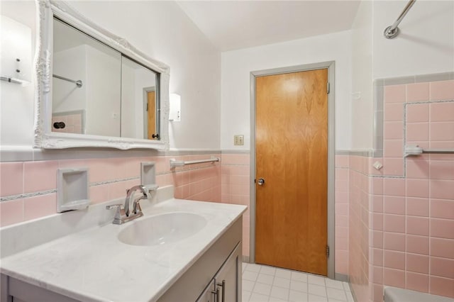 bathroom with tile walls, wainscoting, vanity, and tile patterned flooring