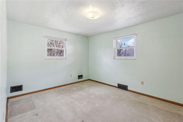 empty room with visible vents, baseboards, and carpet flooring