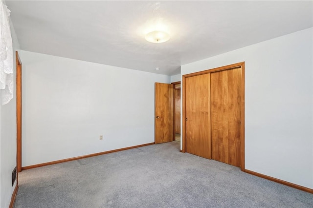 unfurnished bedroom with visible vents, baseboards, a closet, and carpet floors