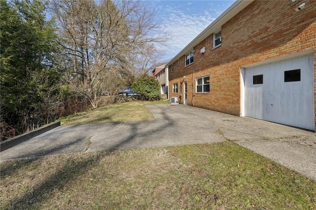 view of side of property featuring brick siding and a yard