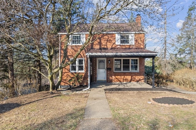 view of front of property with brick siding and a chimney