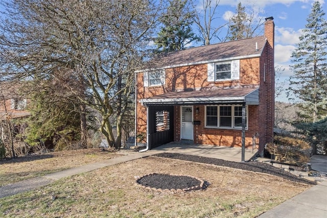 view of front of house with brick siding and a chimney