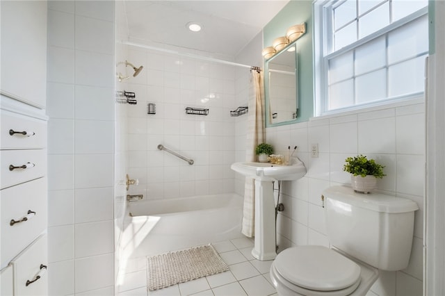 full bathroom with tile patterned floors, toilet, tile walls, and shower / tub combo