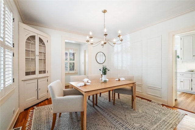 dining room with crown molding, wood finished floors, and a wealth of natural light