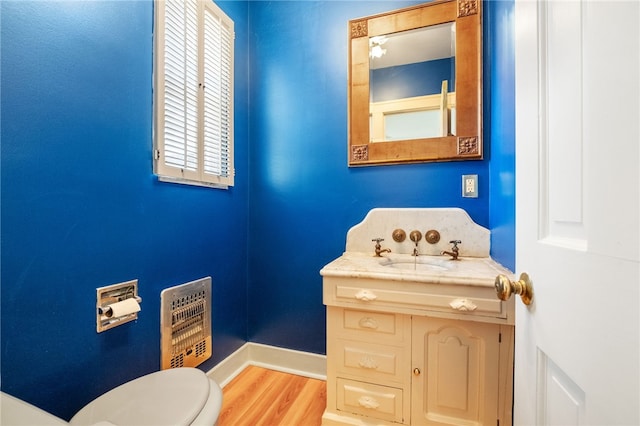 bathroom with baseboards, toilet, wood finished floors, and vanity