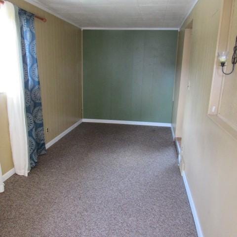 unfurnished room with crown molding, carpet flooring, and baseboards