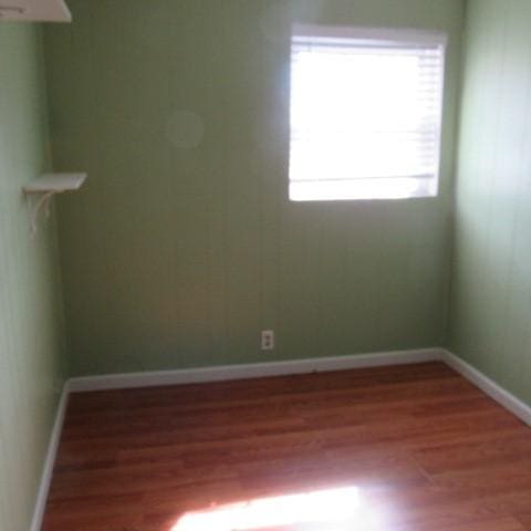 empty room featuring baseboards and wood finished floors