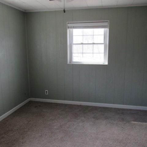 spare room with a ceiling fan and carpet