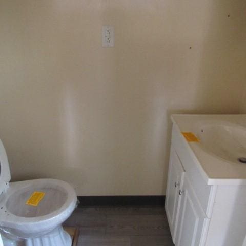 bathroom featuring vanity, toilet, and baseboards