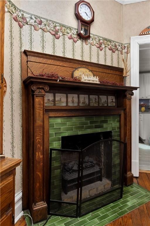 details featuring a tiled fireplace and wood finished floors