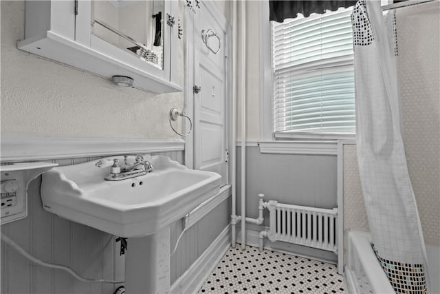 bathroom with shower / bath combo and radiator heating unit