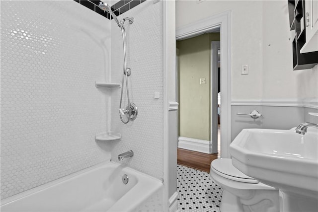 bathroom with baseboards, a sink, tile patterned flooring, bathing tub / shower combination, and toilet