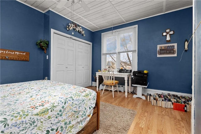 bedroom featuring wood finished floors, a closet, and baseboards