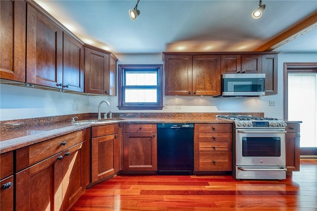 kitchen featuring a sink, light wood-style flooring, and stainless steel appliances