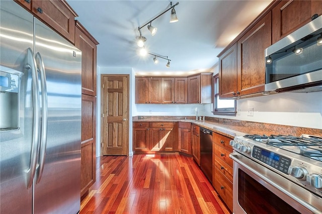 kitchen featuring appliances with stainless steel finishes, wood finished floors, light countertops, and a sink