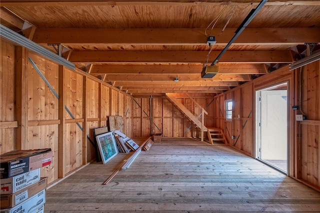 interior space featuring hardwood / wood-style flooring, beamed ceiling, wooden ceiling, and wood walls