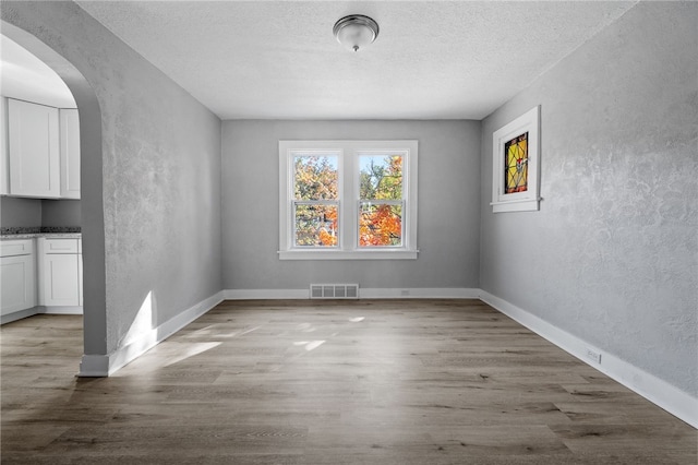 47 Bellanca Ave, Brentwood, PA 15227 - empty room with visible vents, a textured ceiling, wood finished floors, and a textured wall
