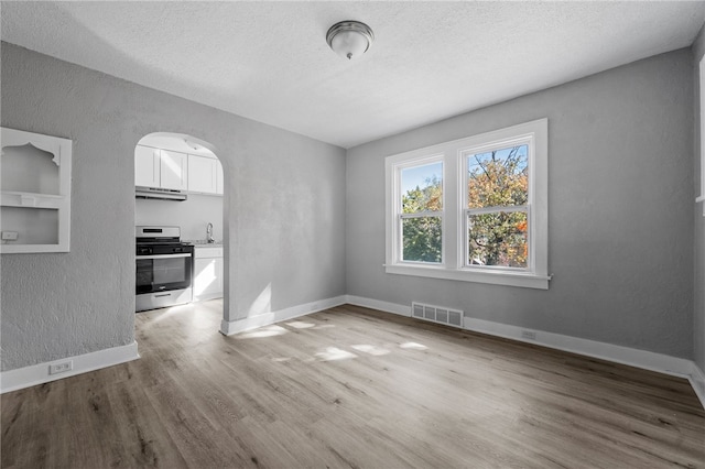 47 Bellanca Ave, Brentwood, PA 15227 - unfurnished dining area with visible vents, arched walkways, baseboards, and wood finished floors