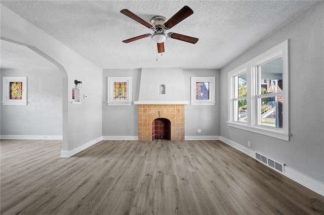 47 Bellanca Ave, Brentwood, PA 15227 - unfurnished living room featuring arched walkways, visible vents, a fireplace, and wood finished floors