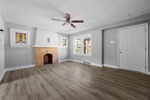 47 Bellanca Ave, Brentwood, PA 15227 - unfurnished living room with wood finished floors, baseboards, visible vents, a textured ceiling, and a tiled fireplace