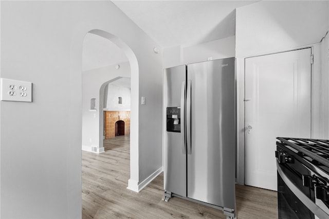 47 Bellanca Ave, Brentwood, PA 15227 - kitchen featuring arched walkways, black range with gas stovetop, light wood-style floors, and stainless steel fridge with ice dispenser