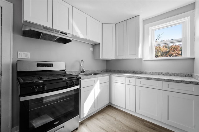 47 Bellanca Ave, Brentwood, PA 15227 - kitchen with stainless steel gas stove, under cabinet range hood, a sink, light wood-style floors, and white cabinets