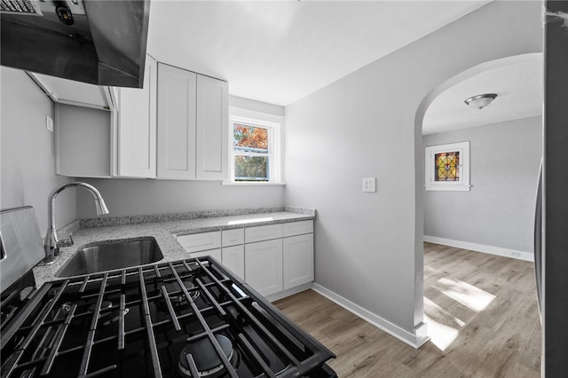 47 Bellanca Ave, Brentwood, PA 15227 - kitchen with white cabinetry, light wood-type flooring, arched walkways, and a sink