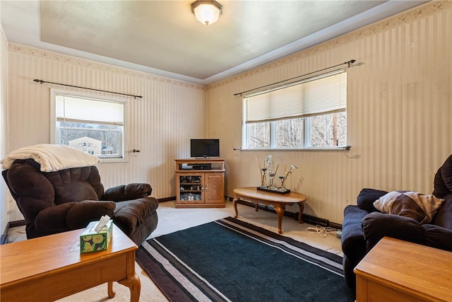 carpeted living area featuring wallpapered walls and baseboards