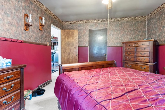 bedroom featuring wallpapered walls, carpet floors, and wainscoting