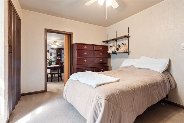 bedroom with light colored carpet, a ceiling fan, and baseboards