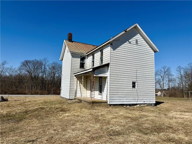 rear view of property featuring a chimney