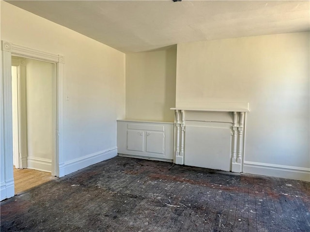 empty room with baseboards and hardwood / wood-style flooring