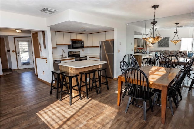 dining area with baseboards, visible vents, and dark wood-style flooring