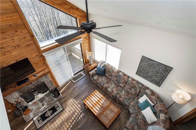 living area with a fireplace, high vaulted ceiling, a ceiling fan, and wood finished floors