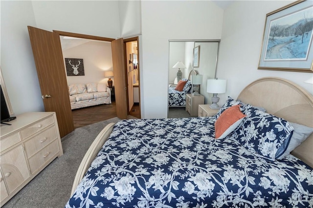 carpeted bedroom with a closet and lofted ceiling