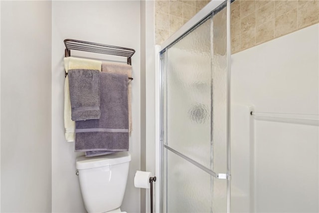 full bath featuring a shower stall and toilet