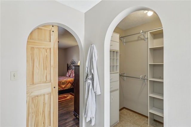 spacious closet featuring arched walkways