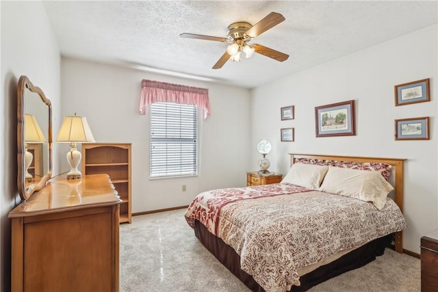 carpeted bedroom with a ceiling fan, baseboards, and a textured ceiling