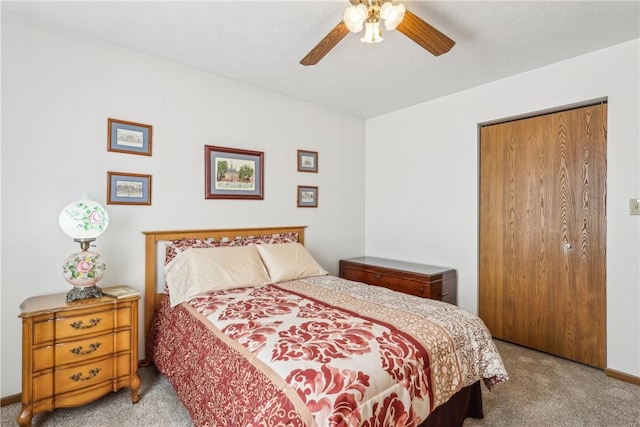 carpeted bedroom with a closet, baseboards, and ceiling fan