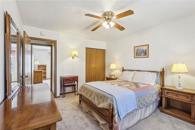 bedroom featuring a closet, light colored carpet, and a ceiling fan