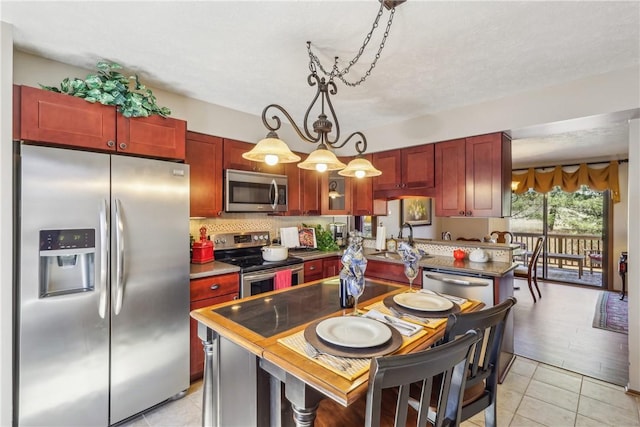 kitchen with a sink, dark brown cabinets, light tile patterned floors, and stainless steel appliances